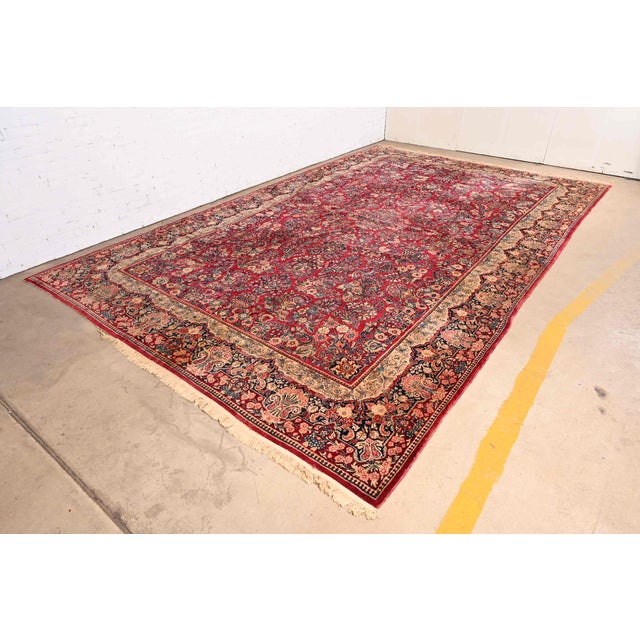 A gorgeous antique hand-knotted Persian Sarouk room size wool rug Circa 1930s Classic floral design, with predominant...