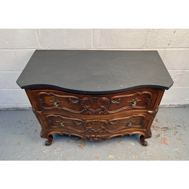 Distinctive Chippendale-style dresser featuring ornate detailing and a refined walnut frame, topped with a sleek slate...