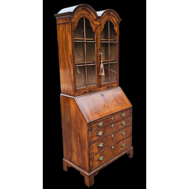 This Late 20th Century Chippendale Style Double Bonnet Secretary is an imposing and classic Georgian-inspired design piece...