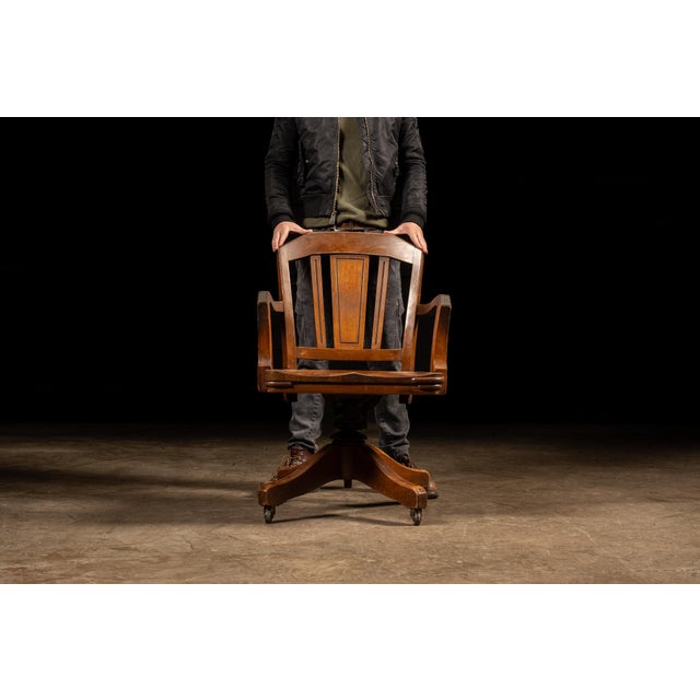 Vintage wooden banker's chair with swiveling height adjustment. This gorgeous banker's chair is a testament to early...