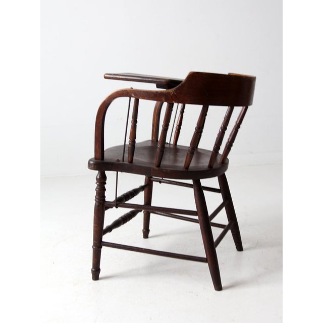 An antique early 20th-century writing arm chair by the Crocker Chair Company of Sheboygan, Wisconsin, featuring a curved...