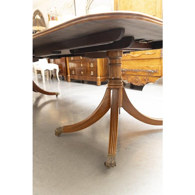 This is an elegant twin-pedestal dining table crafted in richly figured mahogany with a beautifully book-matched top...