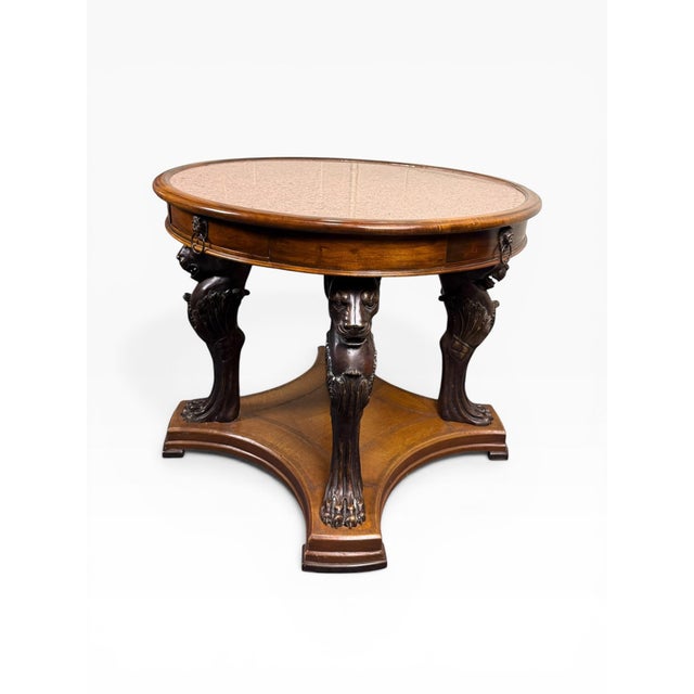 A striking Neoclassical-style game or center table by Theodore Alexander, beautifully crafted with dramatic carved lion...