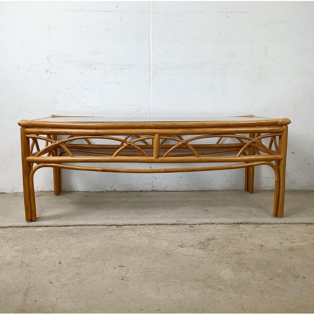 The cathedral arch apron on this vintage rattan cocktail table is the detail that places it firmly in the tradition of...