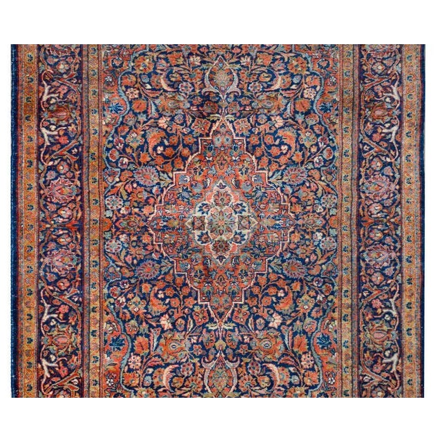 A stunning early 20th century Persian Kashan rug with a traditional central floral medallion living amidst a field of...