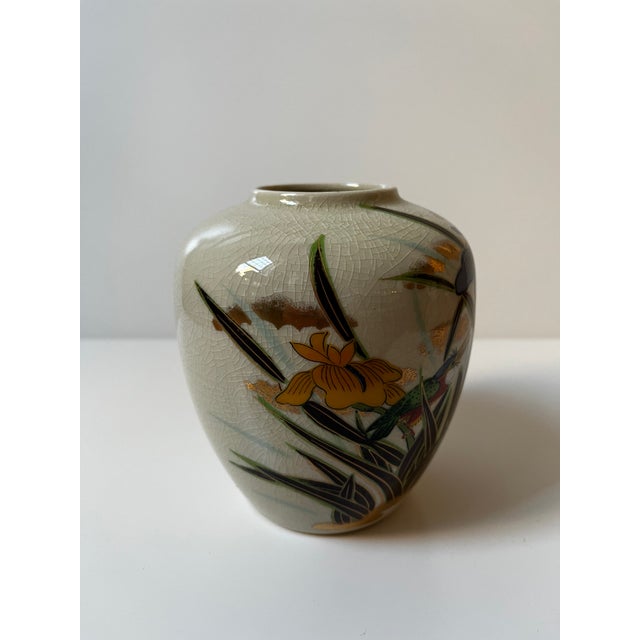 Japanese ceramic vase featuring hand-painted iris flowers and bird decoration on crackle-glaze ground with gold accenting....