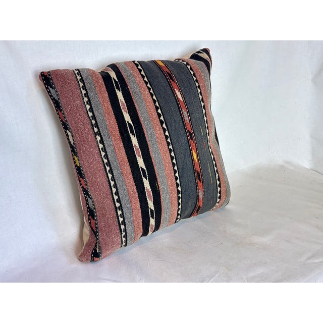 Fabricated from a hand-woven flat-weave rug with red, black, gray, blue, and off white colors. Plain back with zipper...