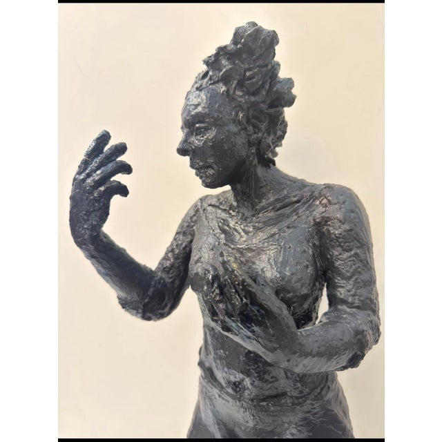 A textured, impressionist composite sculpture of a standing female figure, likely a dancer, caught mid-gesture with one...