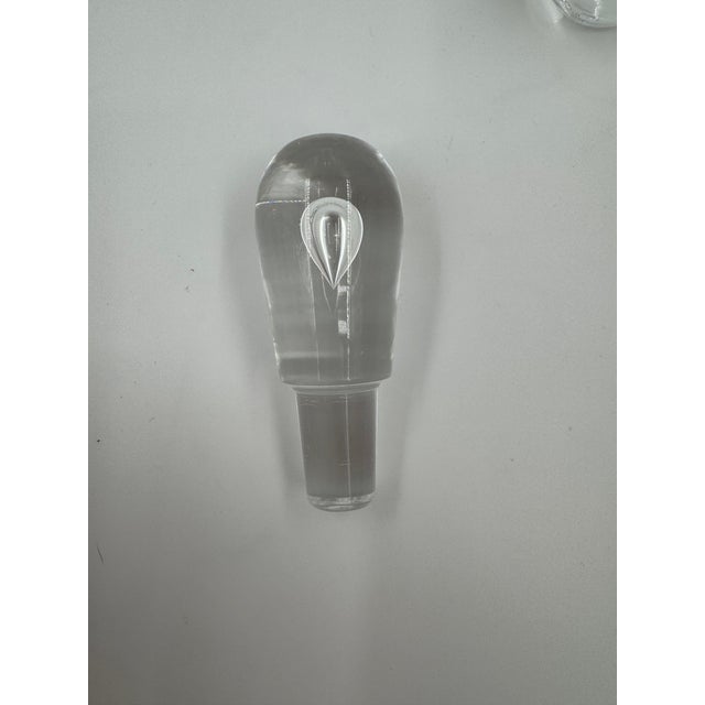 This elegant crystal decanter set by Steuben features a sleek, modern design with a gracefully tapered decanter and...