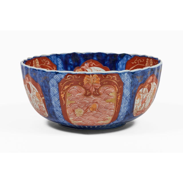 Large Imari punch bowl with a ribbed body and a scalloped or fluted rim, the alternating shaped panels contain elaborate...