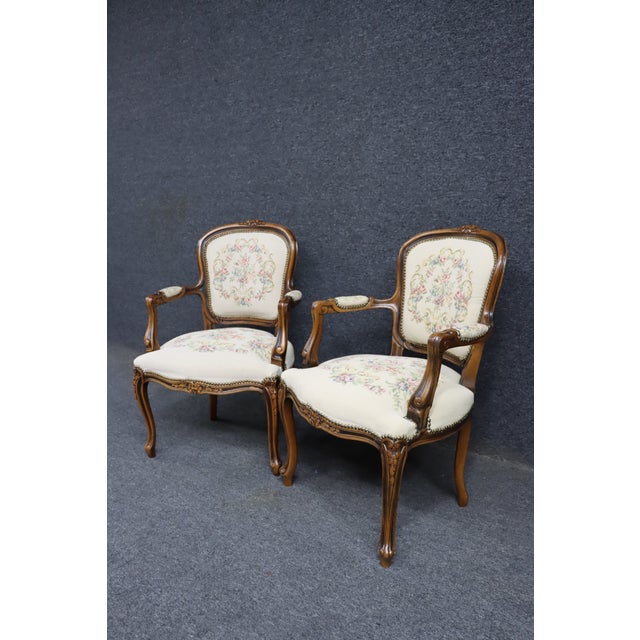 Pair of carved wood armchairs by Chateau d’Ax, made in Italy. Shaped frames with carved crest rails, scrolled arms, and...