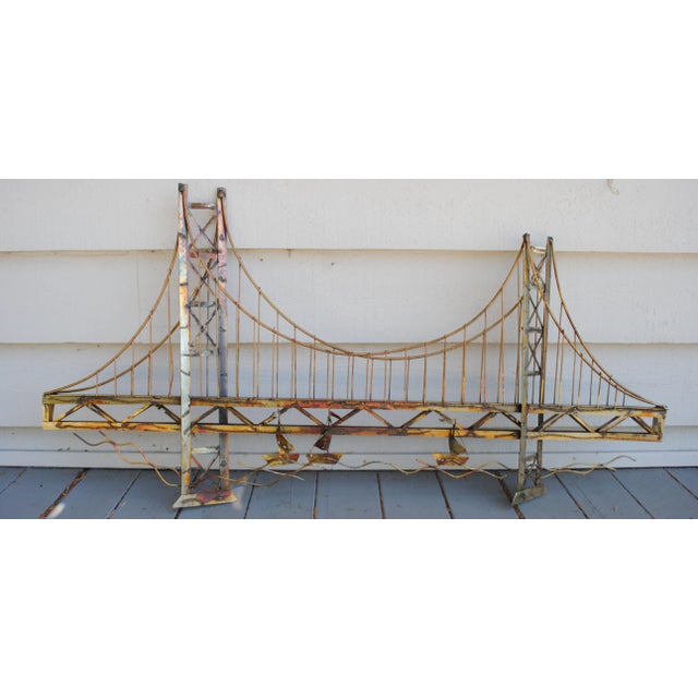 This brutalist metal bridge wall sculpture is certainly of the San Francisco bridge. There are a few sail boats in the...