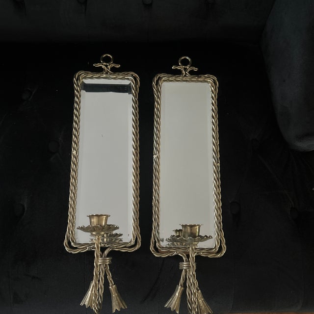 Classic mid century Hollywood Regency gold metal rope and tassle design sconces with a rectangular center mirror. Sconces...