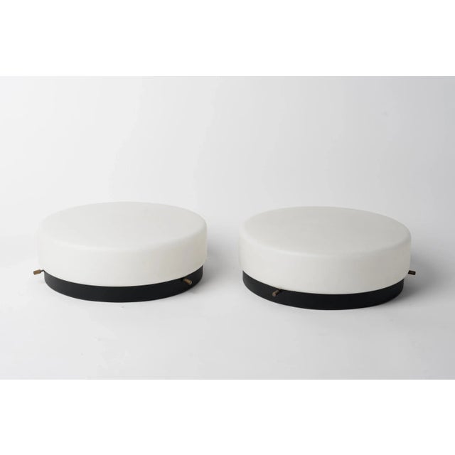 Elegant French 1960s wall or flush mount lights made of milk opaline glass mounted on a black lacquered steel structure....