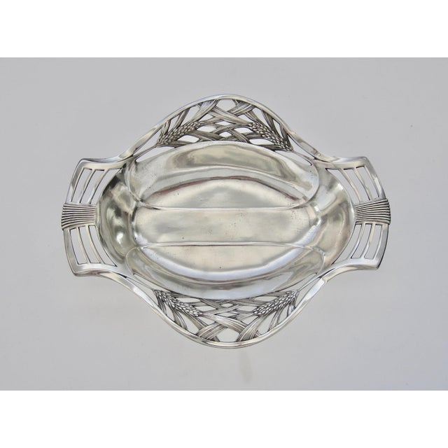 A European double handle Art Nouveau bowl in silvery, highly-polished pewter with a pierced wheat sheaf stem and leaf...
