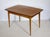 Extendable teak dining table, 1960s. Simple, minimalist design with a gently curved tabletop and slender, tapered legs....