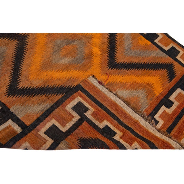 Beautiful vintage Turkish Kilim hand-knotted wool rug with an orange field. This piece has a rust frame and multicolor...