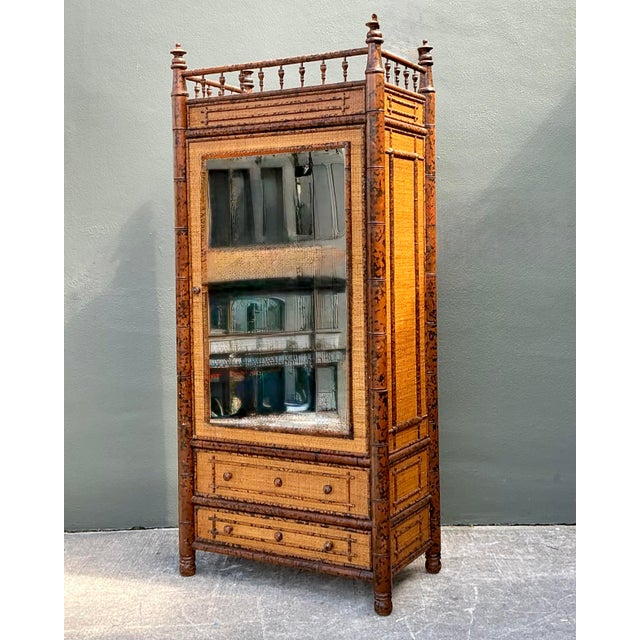Exude the timeless charm of Chinoiserie with this stately vintage tortoise faux bamboo armoire. A quintessential piece of...
