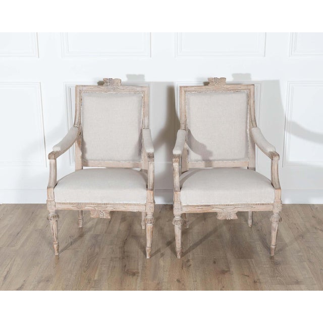 A wonderful pair of Gustavian style armchairs from Sweden, dating to the early 20th century, masterfully carved and full...
