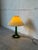 This charming table lamp features a graceful green glass base topped with a classic pleated shade. It delivers warm...