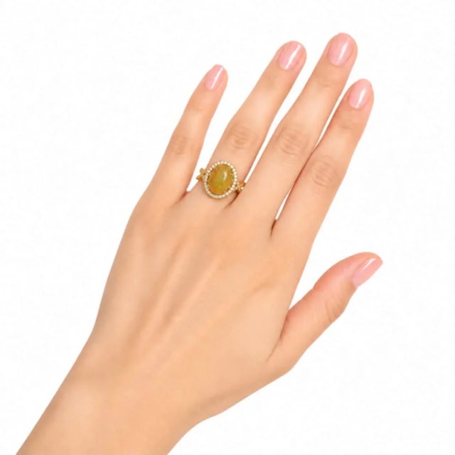 Elegant 14K yellow gold cocktail ring featuring a natural cabochon opal 2.6 carats accented with brilliant round diamonds...