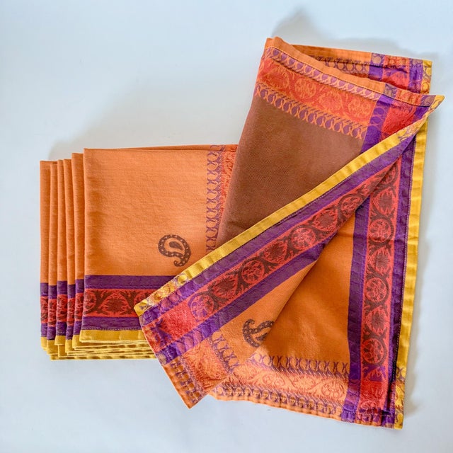 Vibrant and fun, a double sided French jacquard napkin in shades of pumpkin, pomegranate, lavender, umber, and marigold,...