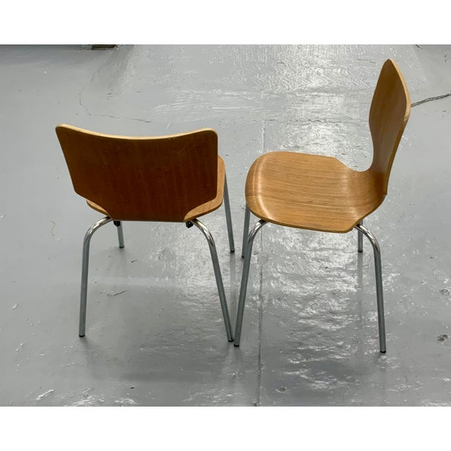 A set of two stackable plywood chairs with a gorgeous flowing shape, the chairs's design is reminiscent of Arne Jacobsen's...