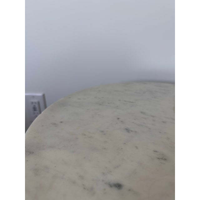 Round marble table with solid black base. Made in India.