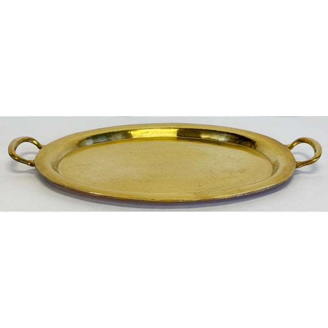 Heavy vintage brass tray oval in shape with handles to each end. Measures 21.5"W handle tip to handle tip and 18"W with...