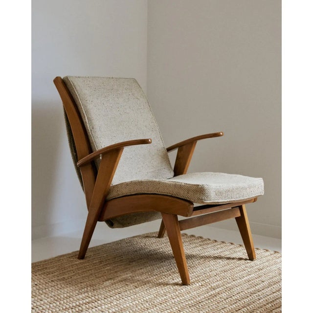 One (1) elegant armchair from France. Lacquered light wood frame with upholstered cushions in a neutral textured fabric....