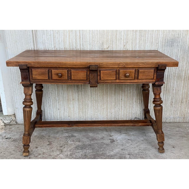 About An 19th century Spanish baroque desk, or writing table made of solid oak with fluted shaped legs joined by solid...