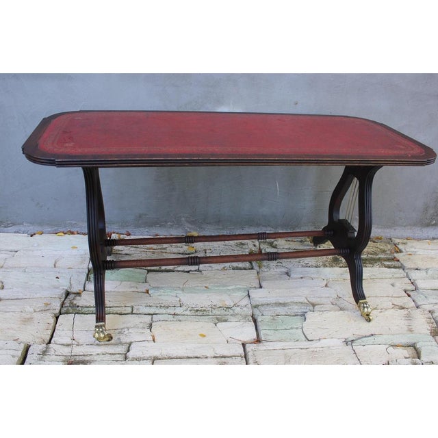 Gorgeous vintage oak and mahogany lyre base rectangular side table, with original wheels and red leather top. The table is...