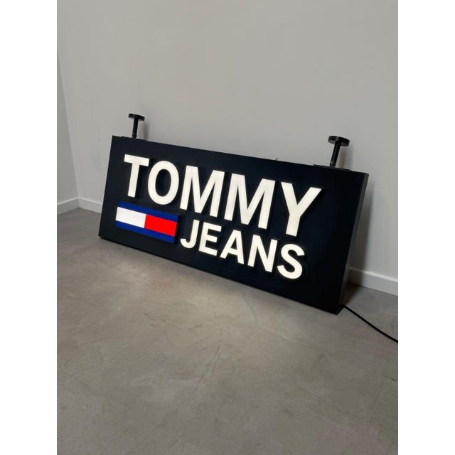 An impressive original Tommy Jeans illuminated advertising sign, formerly used as a retail display piece. Featuring the...