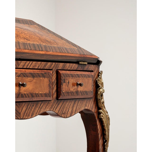 An elegant Louis XV secretary desk combining decorative styling with practical storage. Featuring refined curves and brass...