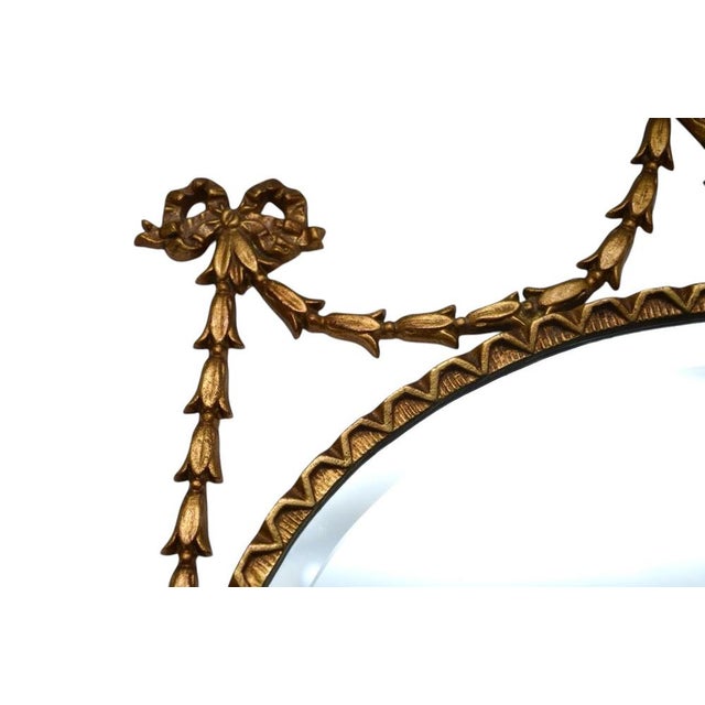 A beautiful antique Adam style gilt metal mirror. This was made in England, it dates from around the 1930’s. This is of...