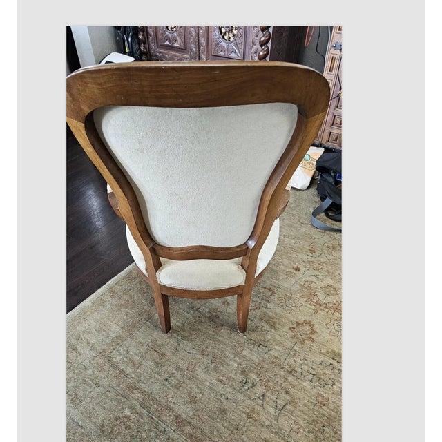 Early 19th Century A Napoleon III armchair on s-shaped legs with a curved frame. The high, rounded backrest as well as the...