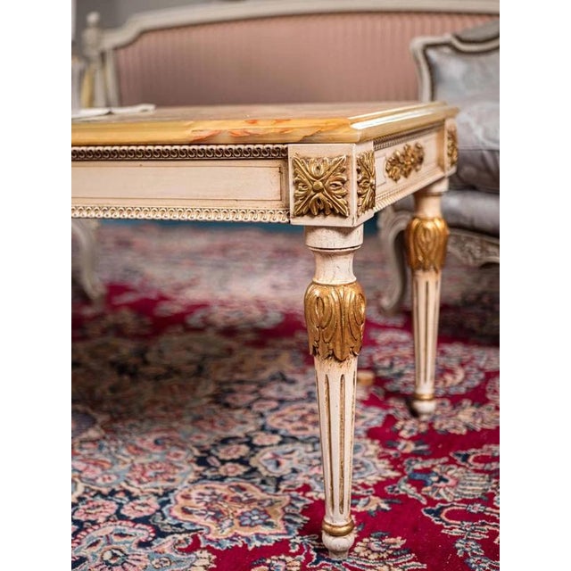 Hand-carved solid beech table in the classicist Louis XVI style with a top made of natural onyx, the top onyx top is...