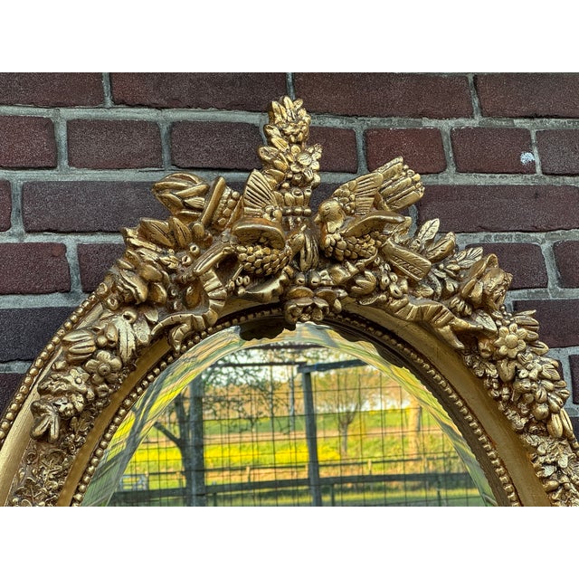 A beautiful vintage French Louis XVI-style oval wall mirror, dating to around 1960. This elegant statement mirror features...