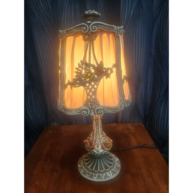 Dating from about 1920, this boudoir lamp is cast metal filigree with original hand painting. The standard base socket has...