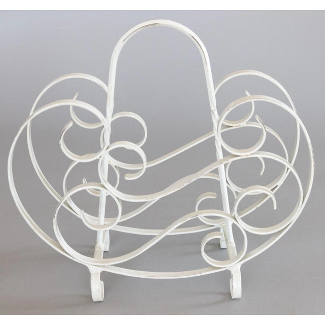 A charming French country style white painted wrought iron magazine rack with stylized scrolls and lovely patina. It's...