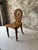 A striking piece of antique craftsmanship, this 19th-century oak side chair features a bold round back with a carved...