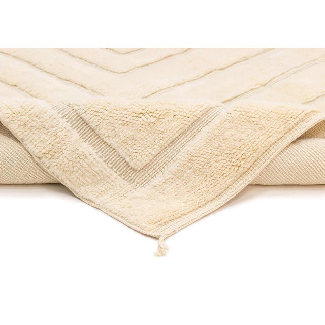 Exquisite hand-knotted wool rug with a handwoven geometric pattern in Ivory, offering depth and a luxurious texture for an...