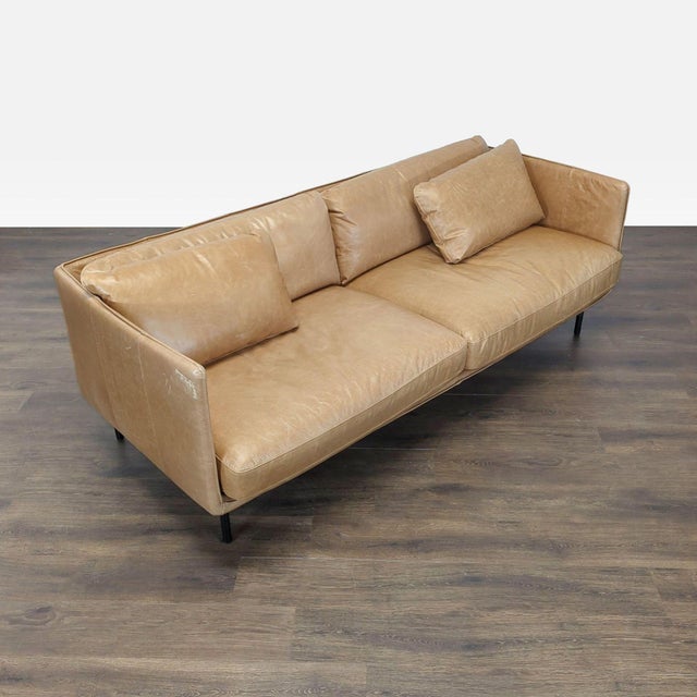 This Crate & Barrel 3-seat sofa features soft tan leather upholstery and a modern, boxy design. The sofa offers...