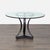 This Kreiss dining set features a round glass top table with a sturdy wood base and four matching chairs. The chairs have...