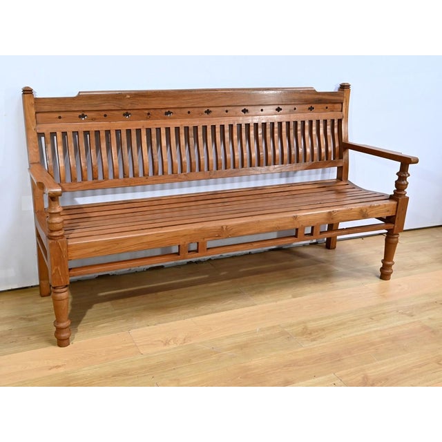 This teak veranda bench, with its classic design and decorative elements. The backrest is made up of vertical slats in...