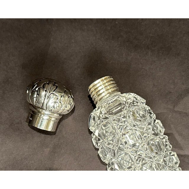 Finest quality and rare brilliant cut glass and sterling silver lay down perfume bottle/vial. Top of repoussé sterling...