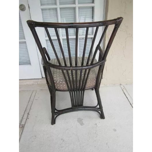 The Palecek Wicker Dining Arm Chair in an upholstered dark wood tone is a stylish and comfortable addition to any dining...