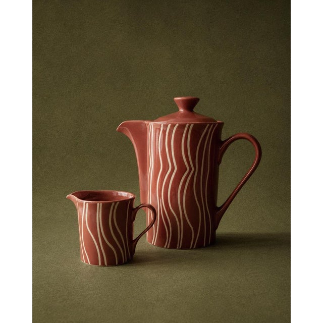 This vintage ceramic tea/coffee set from the 1970s includes a teapot with its original lid and a matching creamer, both...