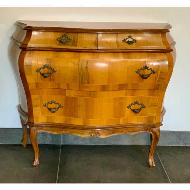 Why does a “petite bombe Italienne” make a person so happy? Is it the inlaid olive wood marquetry veneer with the dainty,...