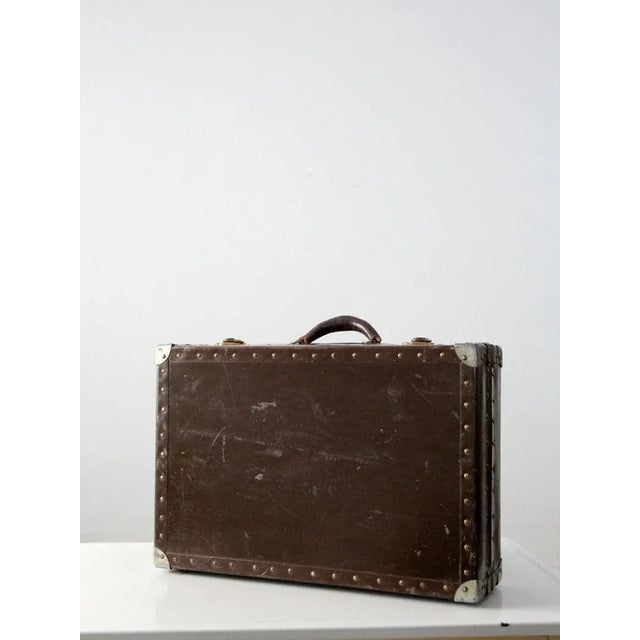 Yee-haw! This is a vintage metal and wood case. The wood frame case is covered with dark brown metal. It features brass...